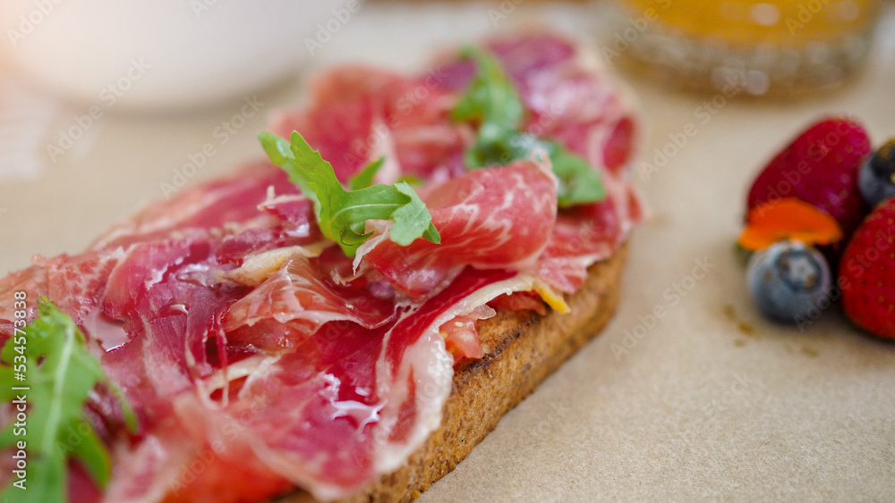 Mediterranean breakfast or brunch with a toast of serrano ham, fruit, coffee and orange juice Mediterranean breakfast or brunch with a toast of serrano ham, fruit, coffee and orange juice