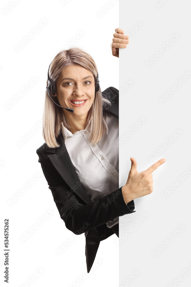Young female call operator standing behind a blank white board and pointing Young female call operator standing behind a blank white board and pointing