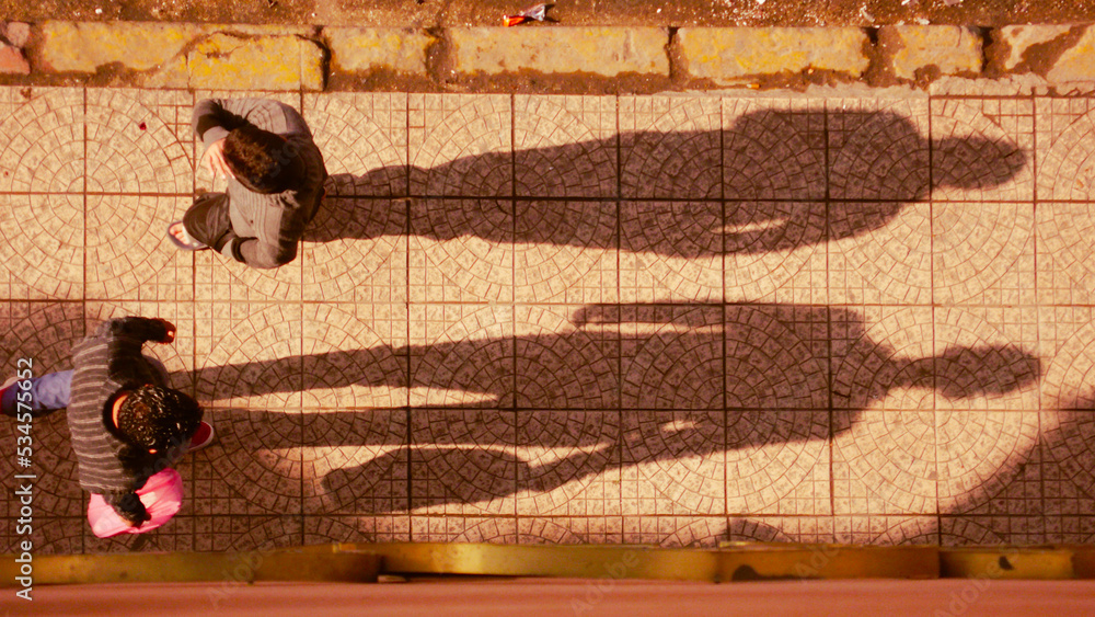 Sombras de personas sobre suelo de mosaico. Shadows of people on mosaic floor.