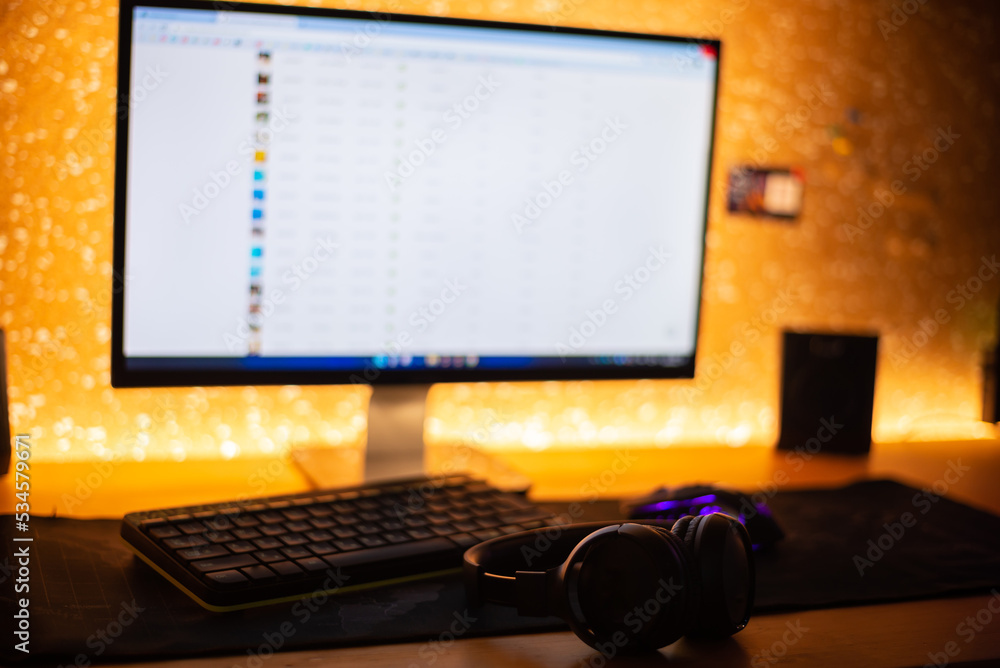 Fototapeta premium Wireless headphones near the computer in a dark room