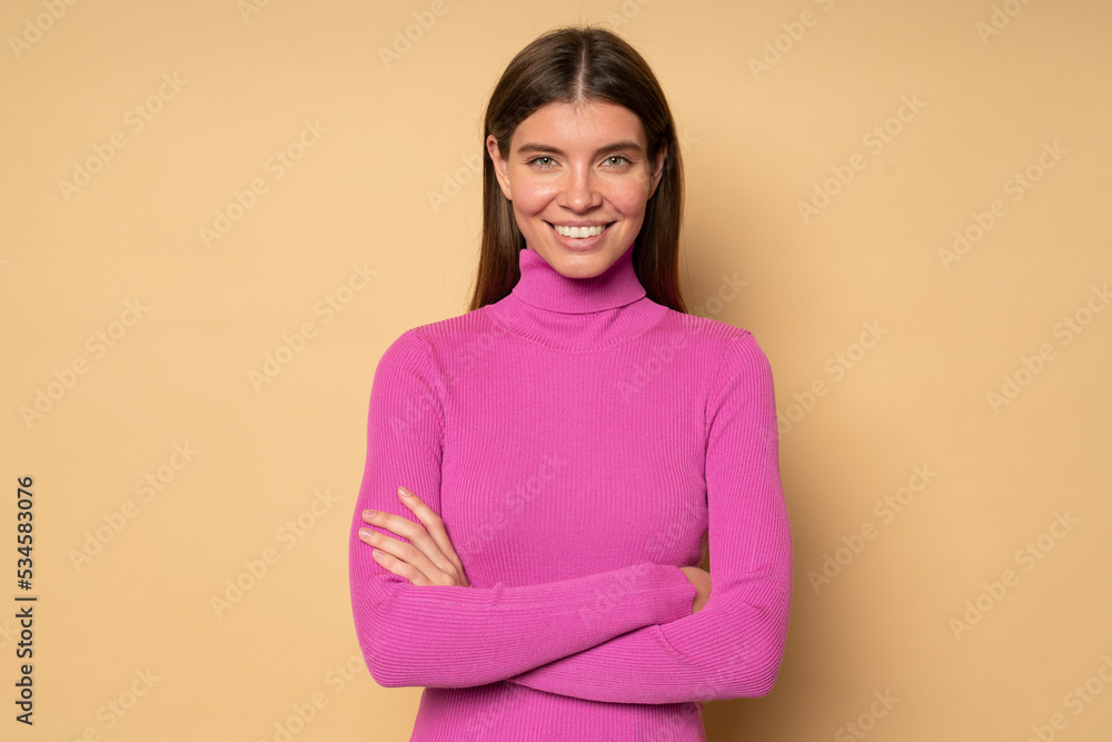 Obraz premium Confident millennial girl standing on brown background with crossed hands smiling
