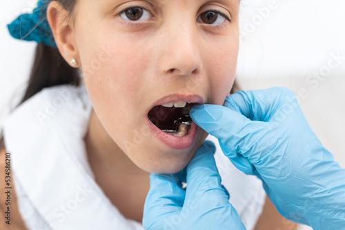 Dentist is check and set dimension of brackets. Talking to girl about braces in her mouth photo