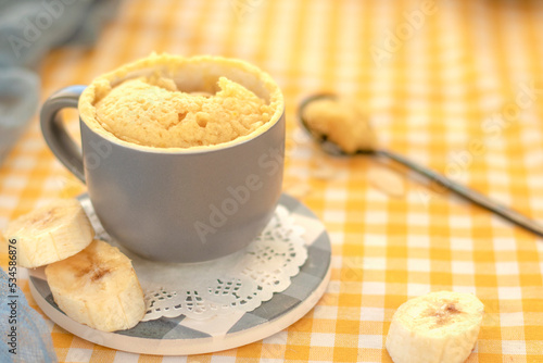 mini cake. Breakfast in a mug. selective focus. homemade Portioned Banana mugcake in small mugs. Easy sweet baking in the microwave idea, With fresh bananas, nuts. Muffin with banana slices cooked  photo