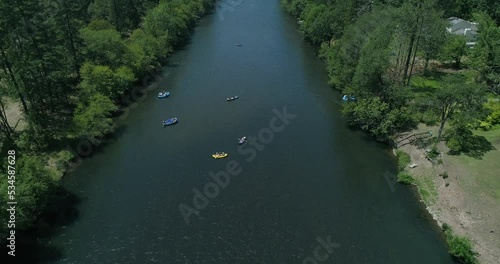 Moving drone shot overlooking a group rafting down a beautiful river in Southern Oregon.