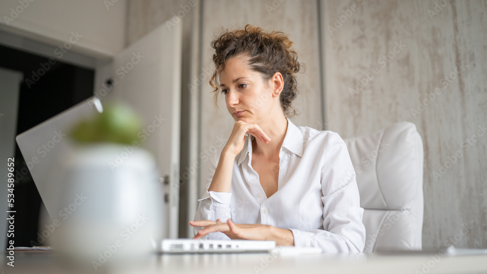 One young business woman back to work in the office working on laptop One young business woman back to work in the office working on laptop