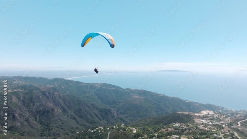 Adrenaline outdoor sport. Beautiful tranquil and calm time in nature above Malibu. Two paragliders flying over mountain top in epic summer day light. Parachutes or paragliding extreme sport experience Adrenaline outdoor sport. Beautiful tranquil and calm time in nature above Malibu. Two paragliders flying over mountain top in epic summer day light. Parachutes or paragliding extreme sport experience