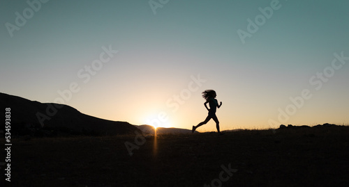 girl runs at sunset in the mountains. © zhukovvvlad
