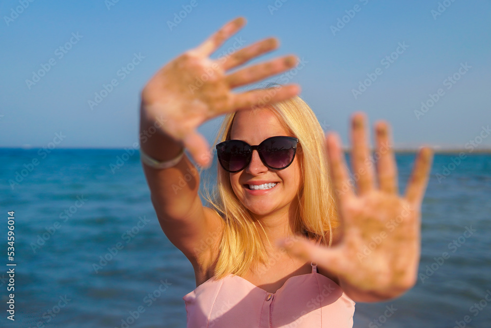 teenage girl blonde with glasses to keep her hands in the sand by the sea teenage girl blonde with glasses to keep her hands in the sand by the sea