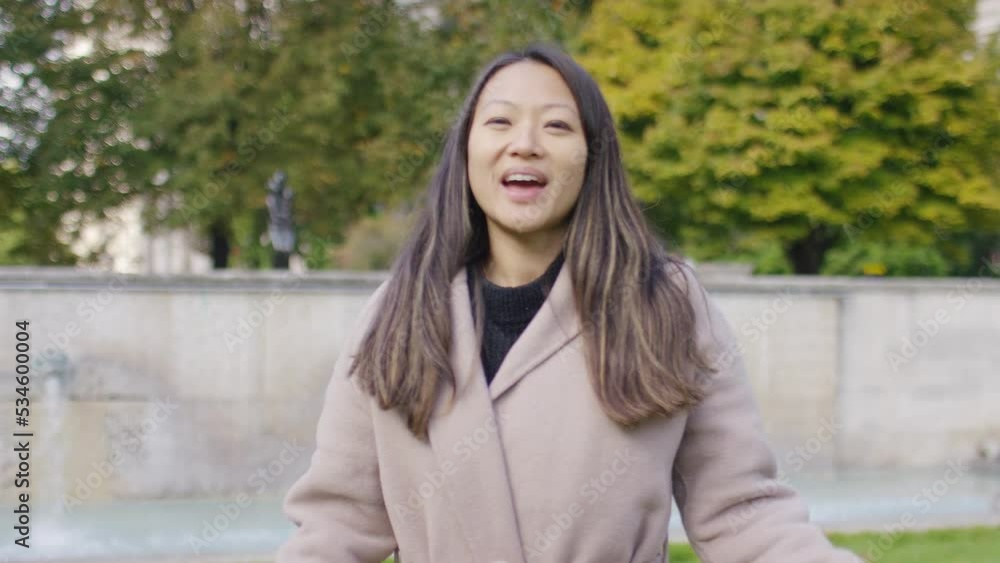 Young female Asian presenter talking and walking to camera in the city Young female Asian presenter talking and walking to camera in the city