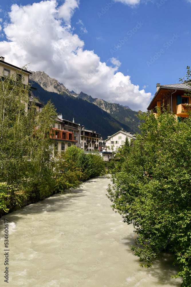 The Arve River that crosses the mountain town of Chamonix-Mont-Blanc with the Alps range in the background in summer, Haute Savoie, France