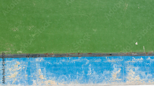 Pared verde y azul desgasta con pintura desconchada en frontón photo