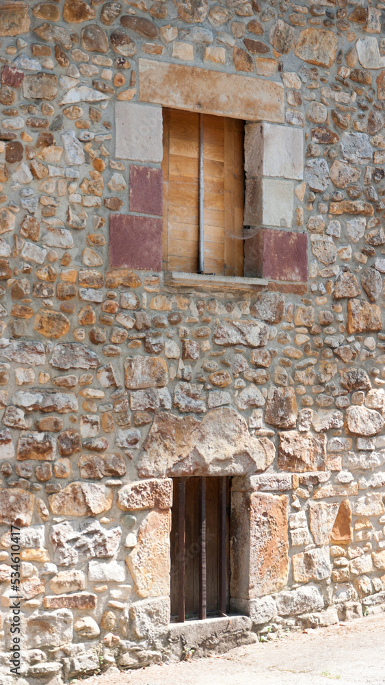 Ventana de madera en fachada de piedra Ventana de madera en fachada de piedra