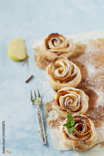 Apple Roses   delicious homemade puff pastry cookies  rustic food composition on a light blue pastel background  cake  confectionery  pastry shop  book   culinary magazine.