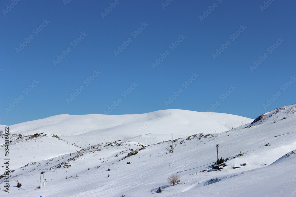 Beautiful landscape of mountains covered with white snow and clear blue sky in the background 