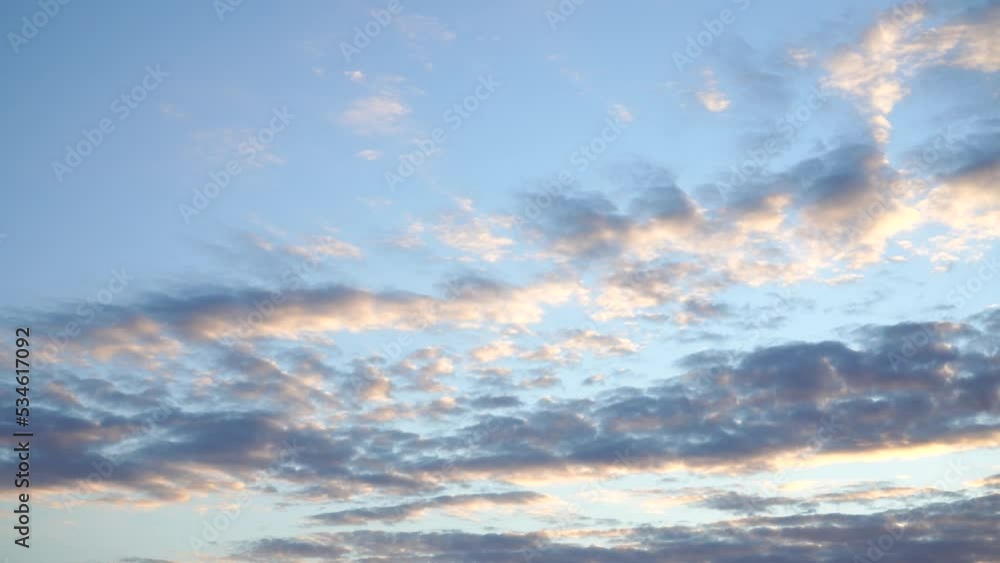 Sunrise cloudy sky landscape - a panorama of sunlit clouds in the early morning in the countryside. Motion scene with the view moving from the sky to the horizon line.