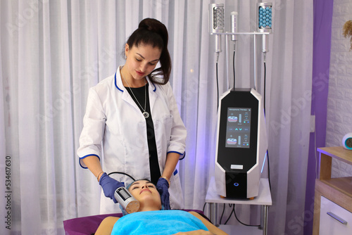 in the beauty salon, a girl gets a body massage with a special electronic massager, body therapy, relaxation, rest, relax