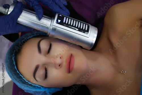 in the beauty salon, a girl gets a body massage with a special electronic massager, body therapy, relaxation, rest, relax