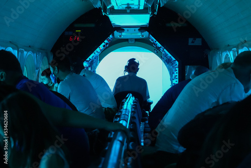 Captain steering a submarine full of tourists during a dive in Mamala Bay near Waikiki Beach in Honolulu, Hawaii