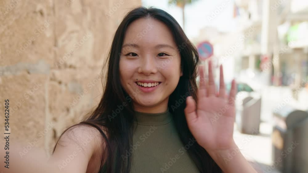 Young chinese woman smiling confident having video call at street Young chinese woman smiling confident having video call at street