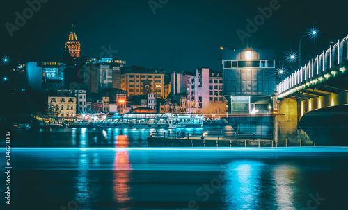 Golden horn halic bridge and boats and city scape galata tower and architecture with night lights  photo