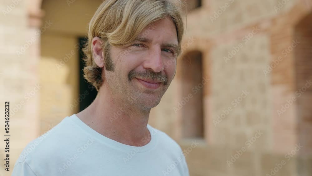 Young blond man smiling confident standing at street Young blond man smiling confident standing at street