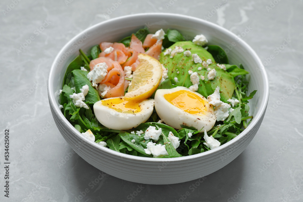 Delicious salad with boiled egg, salmon and cheese in bowl on light grey marble table, closeup Delicious salad with boiled egg, salmon and cheese in bowl on light grey marble table, closeup
