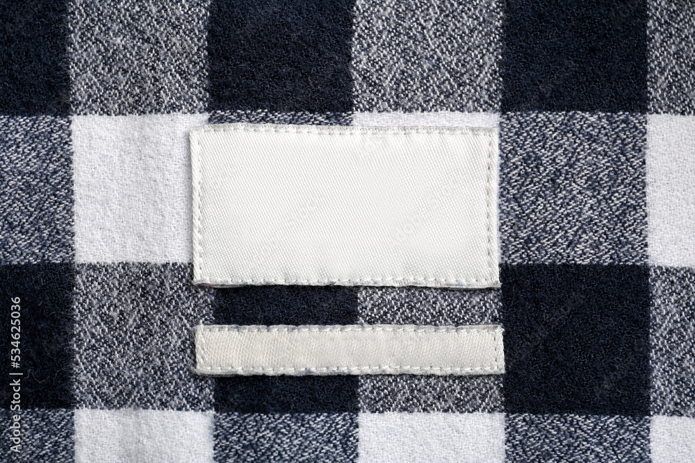 Blank clothing label on checkered shirt, top view Blank clothing label on checkered shirt, top view