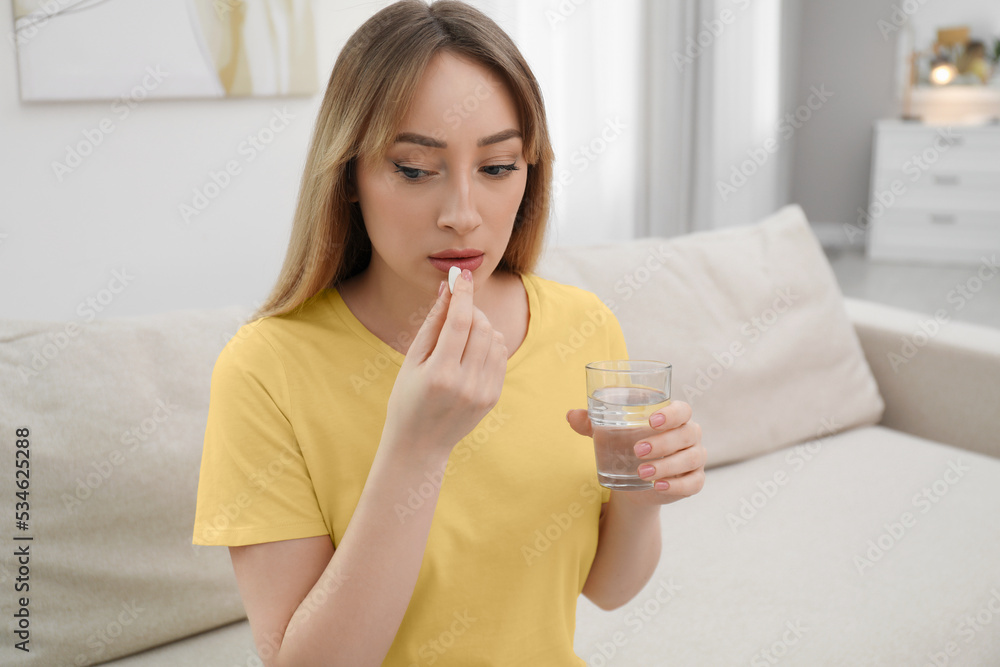 Young woman taking abortion pill at home Young woman taking abortion pill at home