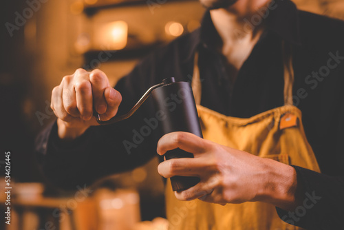 barista holding hand grinde...