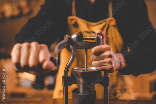 barista holding hand grinde...