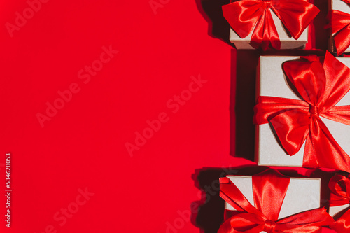 Gorgeous festive Christmas banner or header, holiday presents on red background. Christmas gift boxes on red. Holiday season, New Year. Copy space for text.