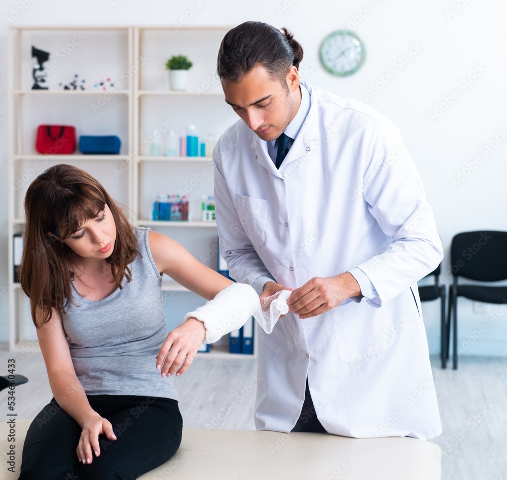 Obraz premium Young woman visiting male doctor traumatologist