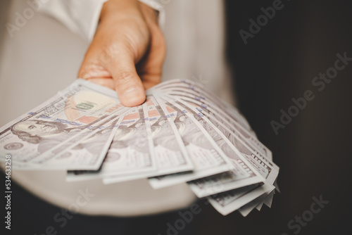 Banknote of 100 dollar bills in hands of rich woman person. Success business female holding cash money for investment. concept of saving finance, exchange bank, american currency, salary payment