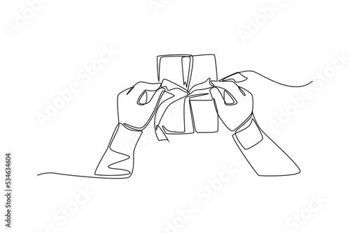 Single one line drawing top of view hand wrapping the gift. Giving season go concept. Continuous line draw design graphic vector illustration.