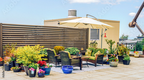 Patio furniture and umbrella on BC rooftop patio garden, mid summer.