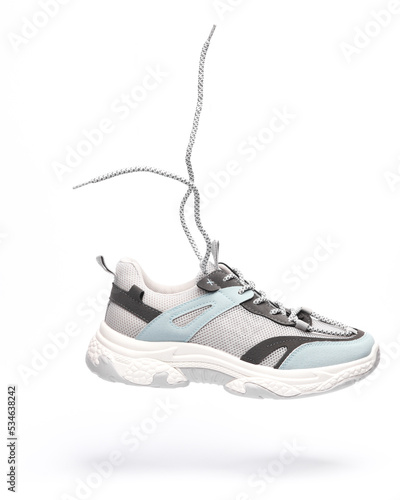 Levitating sneakers with massive sole and flying laces on a white background