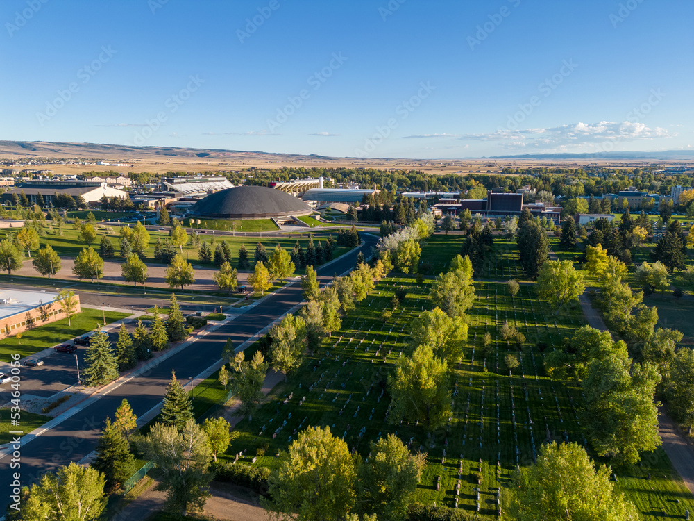 Green Summer Cemetery from air aerial drone image with city and buildings in background in Laramie Wyoming