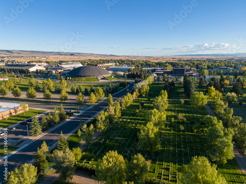 Fototapeta Naklejka Na Ścianę i Meble -  Green Summer Cemetery from air aerial drone image with city and buildings in background in Laramie Wyoming