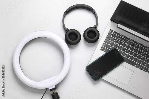 Led ring lamp with laptop, smartphone and headphones on a gray background. Gear for blogging and vlogging. Top view. Flat lay