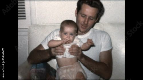 Father and Daughter 1965 - A father sits with his daughter on a sofa in 1965. 