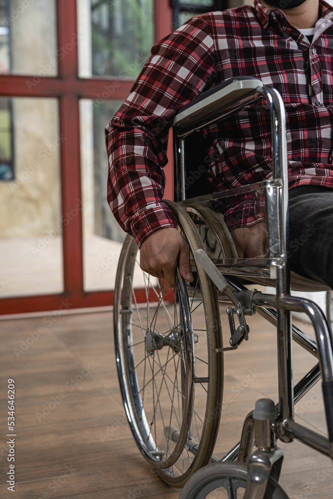 Fototapeta premium Male patient in wheelchair while waiting for a doctor's examination in a private room of a healthcare concept hospital.