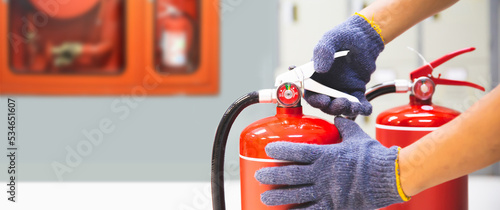 Photography Fire extinguisher has hand engineer checking handle of fire extinguishers to prepare fire equipment for protection and prevent in emergency case and safety or rescue and alarm system training concept