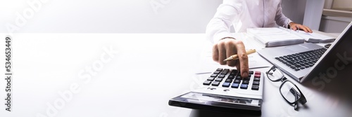 Businessman Calculating Tax Using Calculator photo