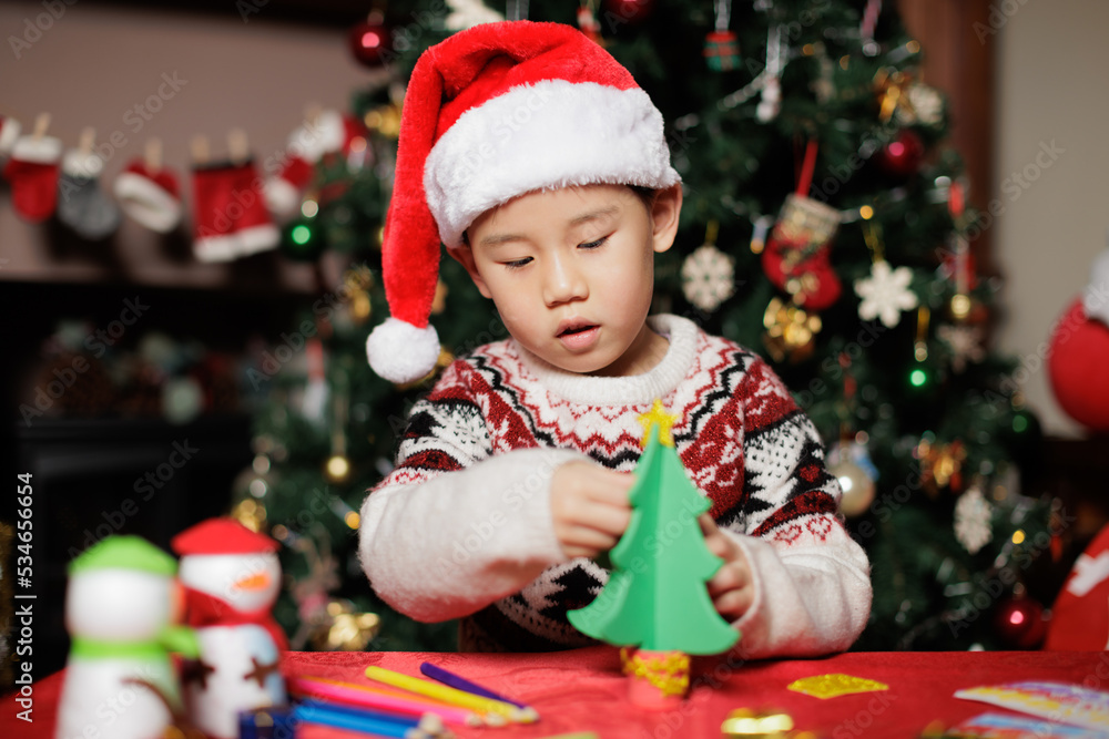 young girl making Christmas tree craft at home young girl making Christmas tree craft at home