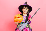 Happy Halloween! young girl with  witch costume and hold a pumpkin against plain  background