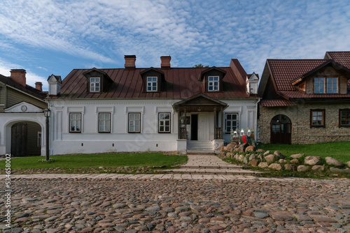 View of historical merchant buildings of estates on the main street of Izborsk Pechorskaya Street on a summer sunny day, Izborsk, Pskov region, Russia photo