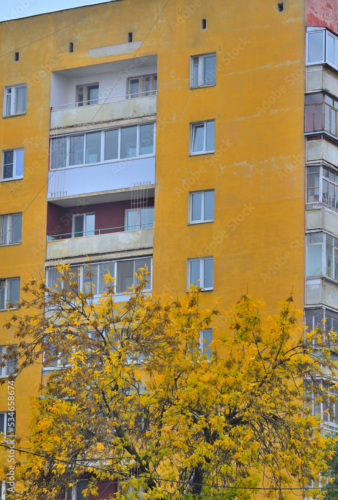 Fragment of the facade of a multi-storey residential building on a cold autumn day