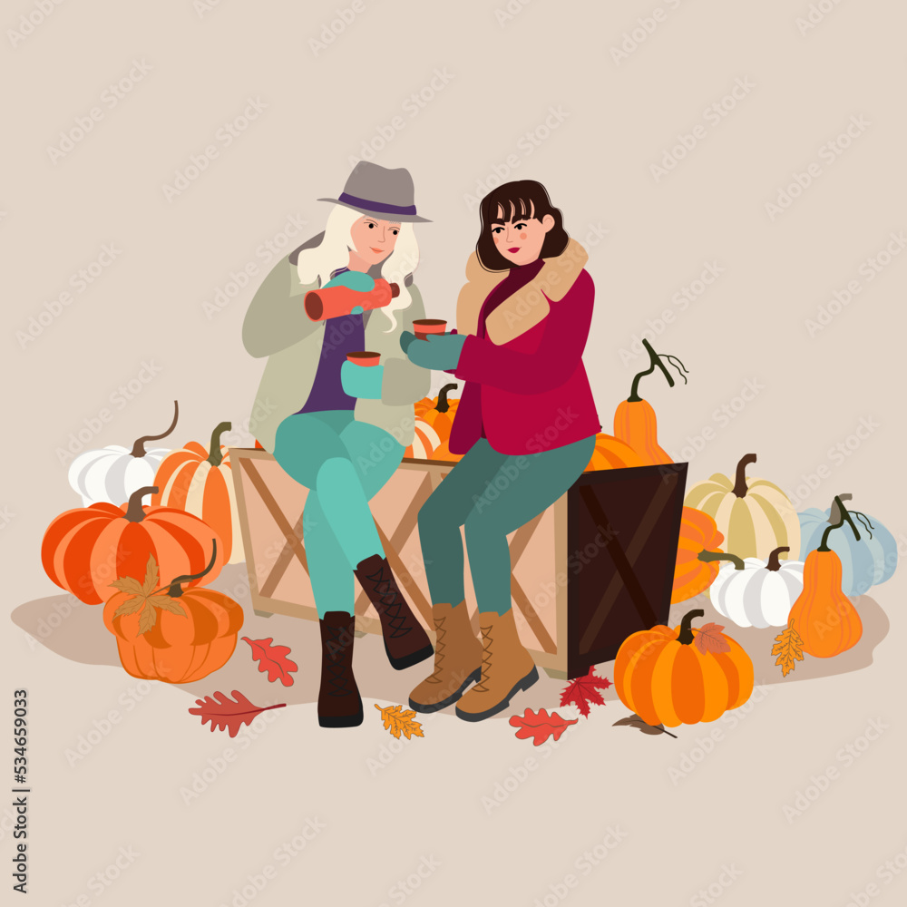 Fototapeta premium Young women drinking coffee on pumpkin patch