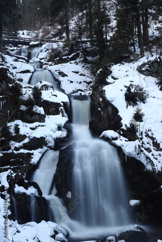 triberg waterfalls in winter with snow. Long exposure in fog, cold ice and bad weather in the Black Forest