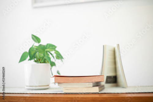 Books stack on wood desk and blurred background in the library room, education background, back to school concept. Image of education knowledge and study at school.